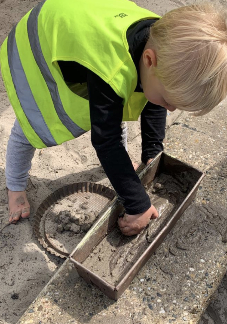 Peuters spelen met water en zand 